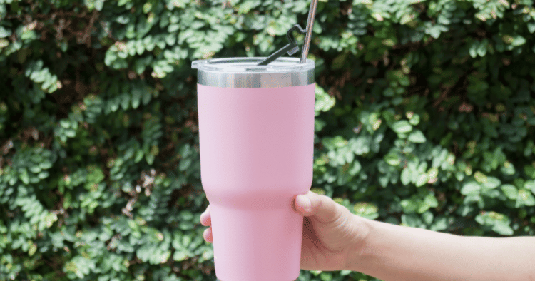 Hand holding a pink custom tumbler