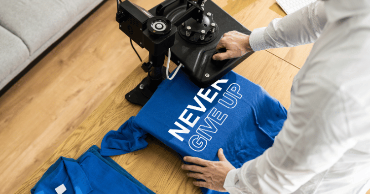 Using DTF printing to apply a design on a blue T-shirt with a heat press.